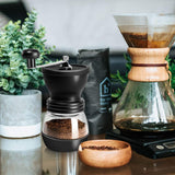 Manual Molinillo de Café - Manivela de Mano Molinillo con Ajustable Cerámica Burr de Carburo/Dos Tarros de Vidrio Transparente/Mango de Acero Inoxidable y Cubierta de Silicona - Portátil para Viajes Camping Trabajo Oficina | Incluye Cuchara de Medición